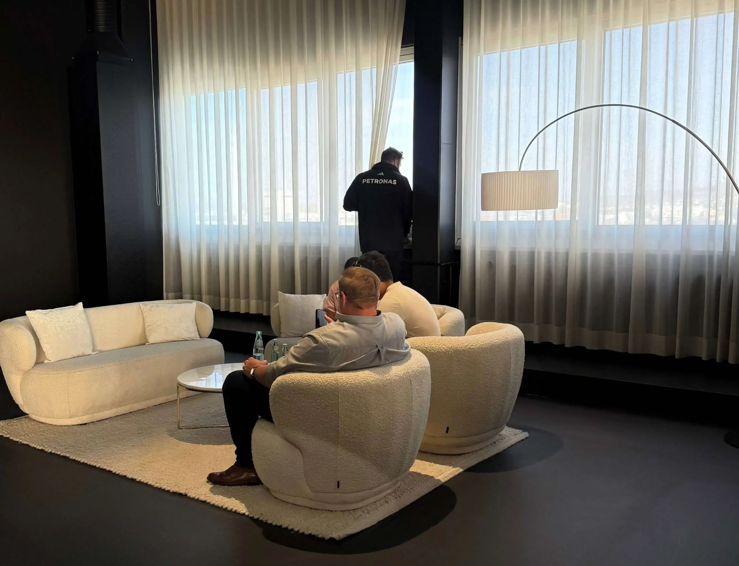 Two individuals in a modern showroom discussing design options for a Mercedes-Benz MANUFAKTUR bespoke car, with fabric swatches on the table