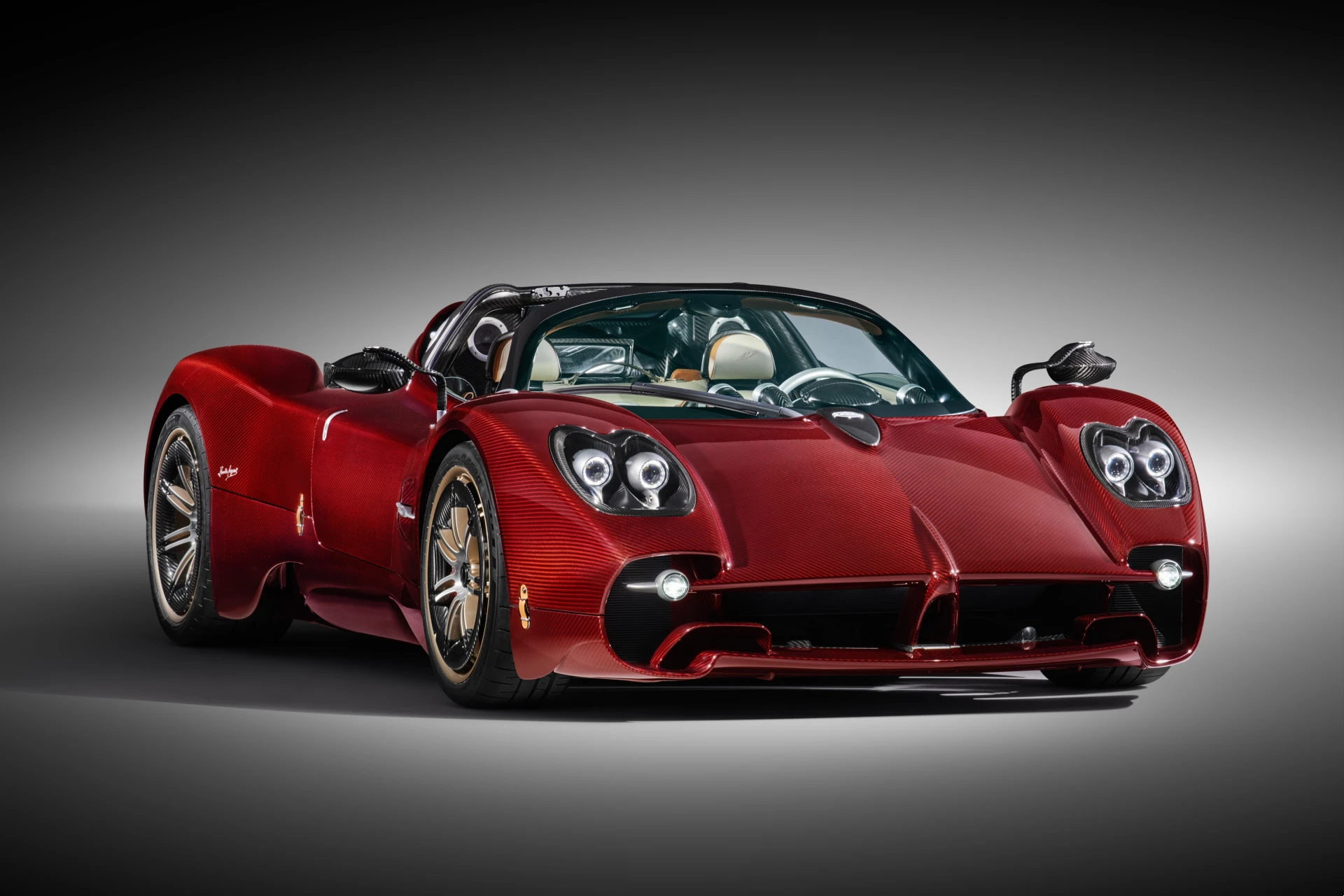 A three-quarter front view of the Pagani Utopia Roadster in Habanero Red exposed carbon fiber, showcased at its exclusive Cape Town debut.