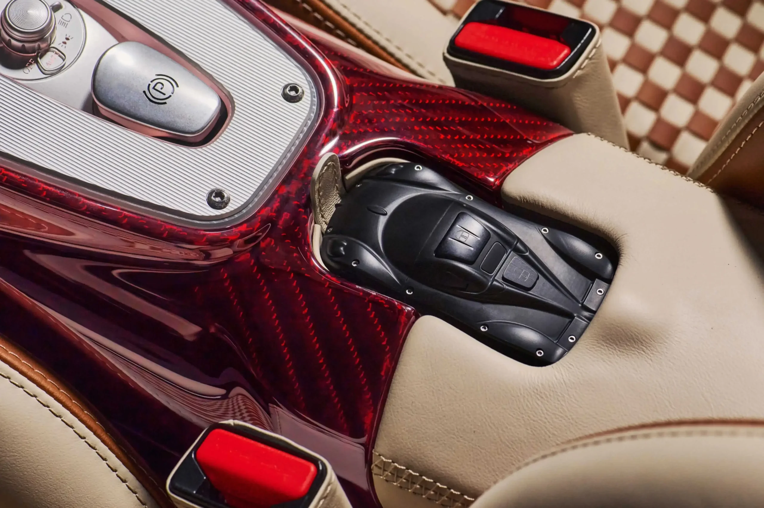 The bespoke Pagani Utopia car-shaped key fob resting on the luxury leather and carbon-fiber center console.