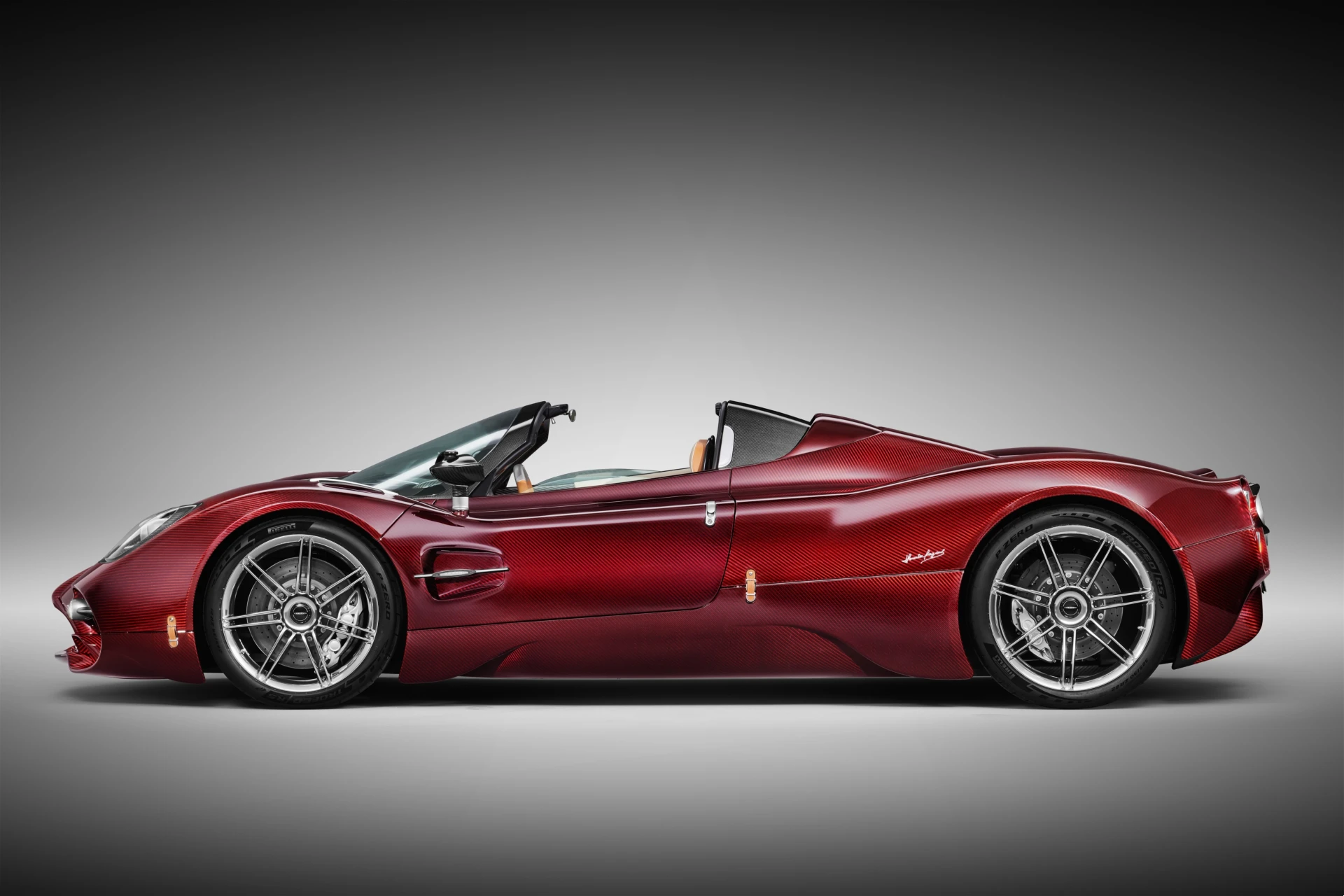 Side profile silhouette of the roofless Pagani Utopia Roadster in Habanero Red, highlighting its sweeping lines.